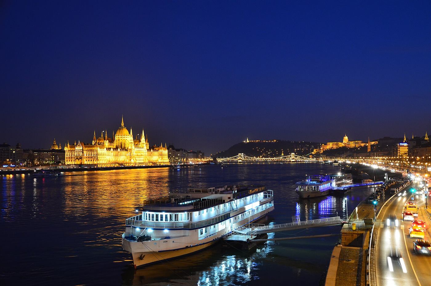 El Parlamento de Budapest iluminado junto al Danubio por la noche